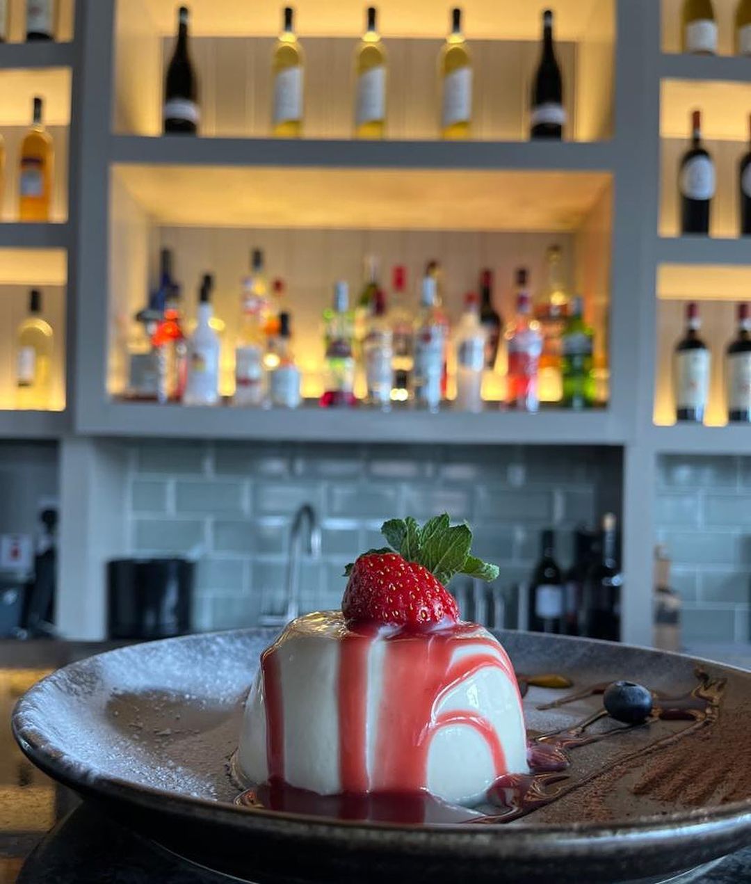 Dessert plated at the bar, with the wine wall behind